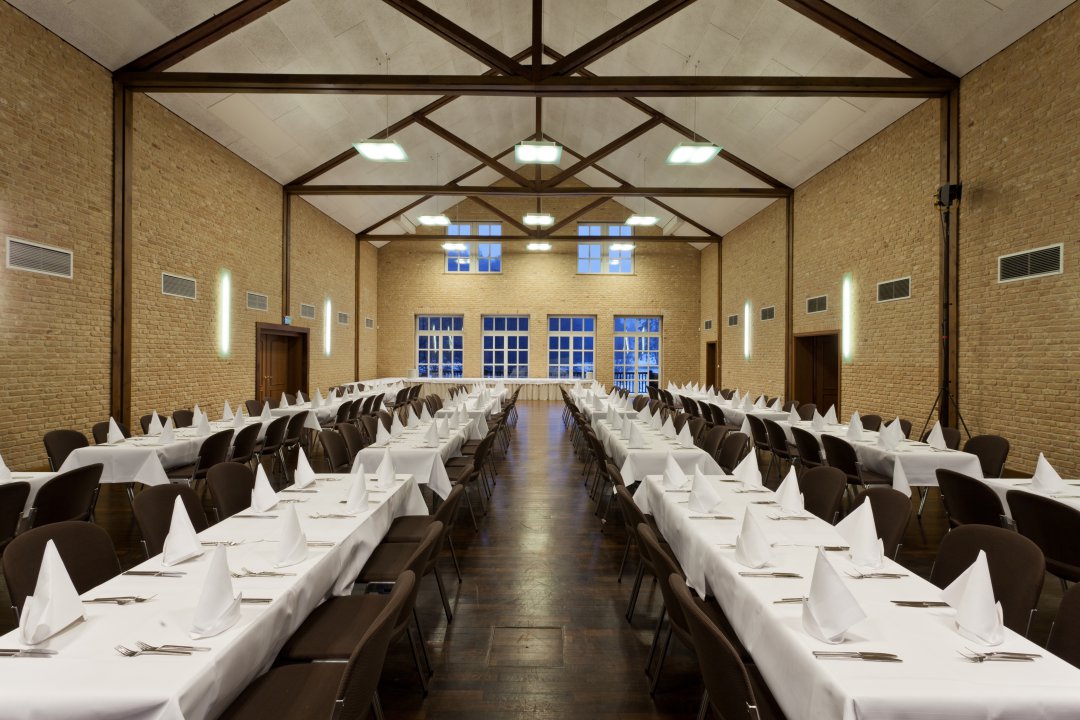 Gedeckte Tischreihen im Saal für Tagungen im Gutshof Itterbach